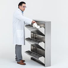 Lab worker in white coat storing shoes in stainless steel cleanroom shoe rack cabinet