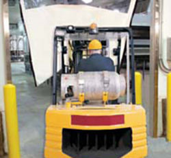 worker driving forklift through the roll up door
