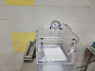 Acrylic vacuum chamber to check for leaks in milk cartons