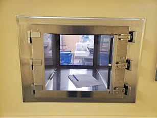 Stainless steel pass-through chamber for a sterile compounding cleanroom