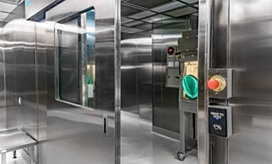 Cleanroom entry door with window and view of hazardous compounding isolator