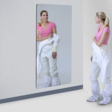 woman garbing in front of wall-mounted cleanroom mirror with round corners