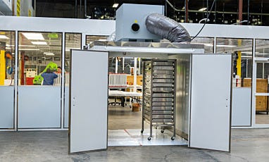 Humidity-controlled drying room with doors open and a cart inside
