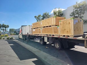 Flatbed truck carrying crated modular cleanroom and filter fan units