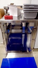Floor-mounted stainless steel pass-through with cart in a compounding pharmacy