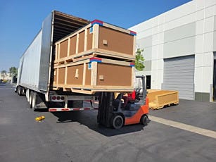 Forklift loading cleanroom crates into truck