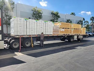 Loaded flat bed truck with crated custom cleanroom and Filter Fan Units