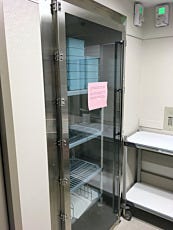 Floor-mounted pass-through chamber for drug cart movement