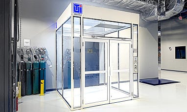 Modular cleanroom with clear panels, double doors, and integrated control panel