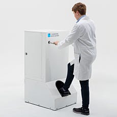 Photo of a large rugged shoe cleaner being used by a man in a lab coat before beginning lab work