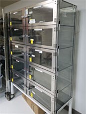 Large desiccator cabinet on a mobile stand used to store radio frequency parts
