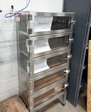 A plastic desiccator cabinet on a stand with a gas feedline attached for dry inert storage