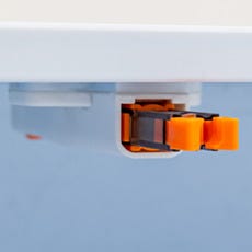 Close-up of the push-latch mechanism on the polypropylene wall-mounted shoe storage cabinet, securing the flip-down compartment door