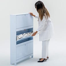 Lab technician opening the middle flip-down compartment of shoe storage cabinet at a comfortable ergonomic height