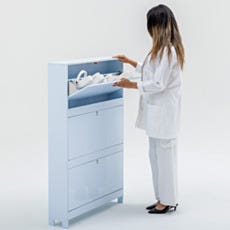 Lab technician opening the top flip-down compartment of wall-mounted shoe storage cabinet