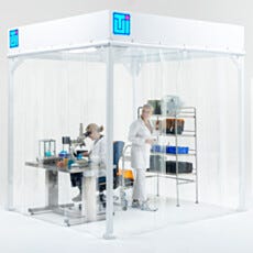 Two Lab Technicians in White Coats Working Inside Modular Softwall Cleanroom with Equipment