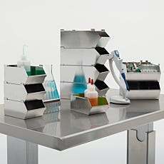 laboratory equipment on a stainless steel table including stacked steel totes