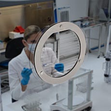 stainless steel talk-through mounted on clear acrylic window in cleanroom setting