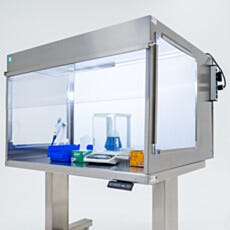 Laminar flow hood interior with balance, pipette tips, and flask