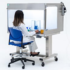 Lab technician working inside a horizontal laminar flow hood