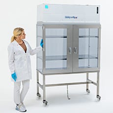 lab technician opening vertical laminar flow hood with stainless steel doors