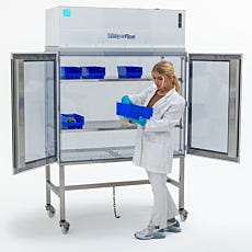 lab technician examining  storage bin inside vertical laminar flow hood