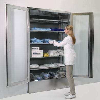 Recessed, aseptic, wall-mounted cabinet stores garments, consumables and supplies