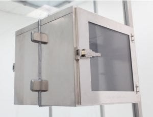 Stainless steel pass-through chamber installed in tempered glass wall panel.